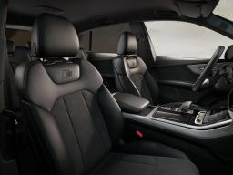 Czarne skórzane sportowe fotele S we wnętrzu Audi Q8, widok na przednie siedzenia i konsolę środkową