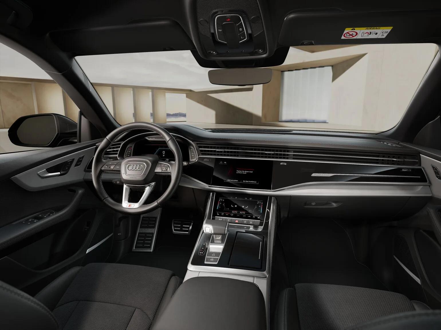 Czarne wnętrze Audi Q8 TDI quattro tiptronic 2026, widok z tyłu na kokpit, kierownicę i dwa ekrany centralne