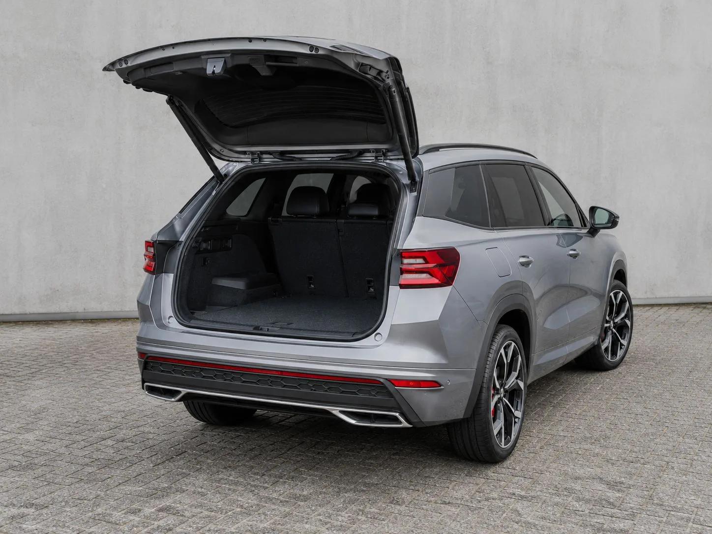 Srebrna Škoda Kodiaq RS z otwartą klapą bagażnika, widok z tyłu pod kątem, pokazana przestrzeń bagażowa