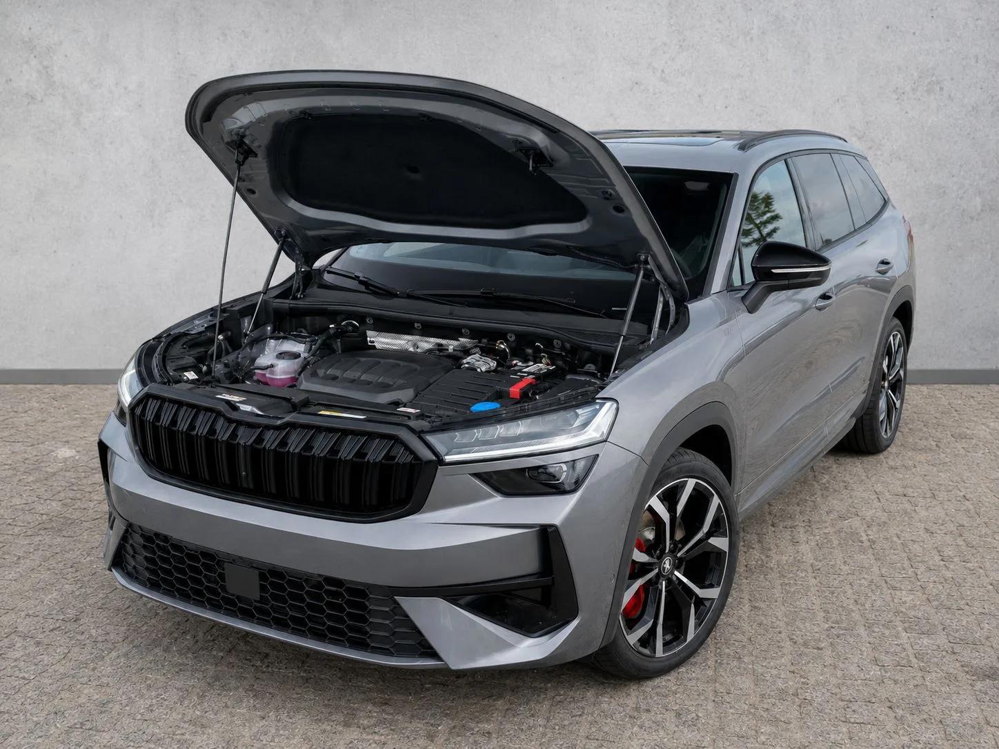 Szara Škoda Kodiaq RS z otwartą maską, widok z przodu pod kątem, odsłonięta komora silnika i czarne felgi