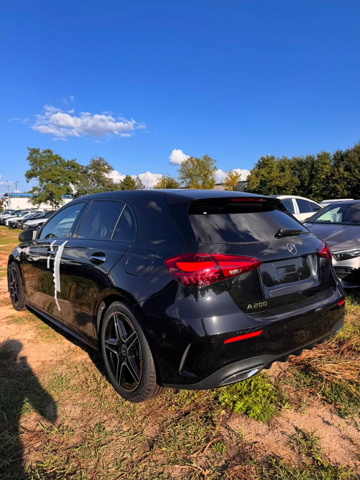 Czarny Mercedes-Benz A 200 hatchback AMG, widok z tyłu i z boku na placu samochodowym