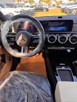 Wnętrze Mercedesa-Benz A 200 Hatchback AMG z kierownicą, cyfrowymi zegarami i ekranem multimedialnym na postoju
