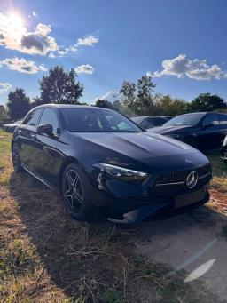 Czarny Mercedes-Benz A 200 Hatchback AMG, ujęcie z przodu pod kątem na tle drzew i innych samochodów