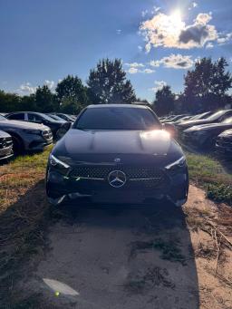 Czarny Mercedes-Benz A 200 hatchback AMG, ujęcie z przodu na placu samochodowym pod błękitnym niebem