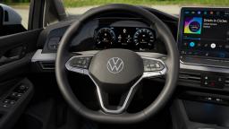 Wnętrze Volkswagena Golfa z kierownicą, cyfrowymi zegarami i ekranem multimedialnym na postoju